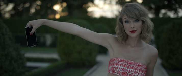 Taylor Swift in the Blank Space music video, holding a phone at arm's length — Justin's actual phone, used in the shot.